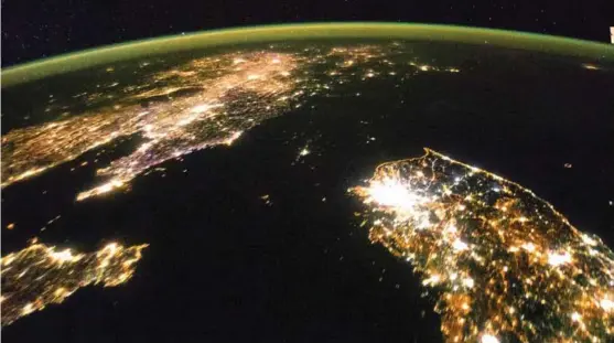  ?? FOTO: NASA, REUTERS/NTB SCANPIX ?? Bildet tatt fra den internasjo­nale romstasjon­en viser det Yeonmi Park kaller «klodens mørkeste sted» – Nord-Korea. I nedre høyre hjørne ser man et opplyst Sør-Korea og oppe til venstre et opplyst Kina. Mellom ligger Nord-Korea med bare noen få lyskilder.