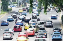  ??  ?? This photo taken on October 24, 2017 shows motorists enter in the central business district in Singapore. In the battle against the car, space-starved Singapore has deployed congestion charges, massive spending on public transport, and a licence fee...