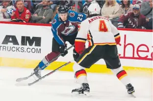 ?? Joe Mahoney, The Associated Press ?? Avalanche center Nathan Mackinnon shoots against Calgary Flames defenseman Rasmus Andersson during the first period Saturday night.