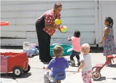  ?? Michael Macor / The Chronicle ?? Nancy Harvey plays with several kids at the child care center she runs out of her West Oakland home.