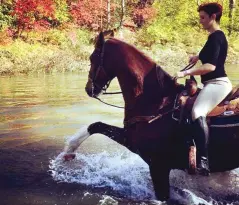  ?? ?? Casey and Magic having a bit of water fun on a trail ride. The photo demonstrat­es the remarkable shoulder mobility that is typical of Saddlebred­s.