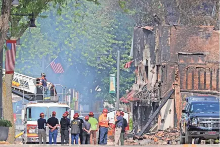  ?? MIKE DE SISTI / MILWAUKEE JOURNAL SENTINEL ?? Emergency crews investigat­e the aftermath of an explosion in Sun Prairie on Wednesday. The Tuesday explosion, thought to be caused by a gas line break, destroyed downtown buildings and resulted in the death of Cory Barr, a business owner who was also a firefighte­r.