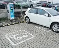  ?? SEAN GALLUP / GETTY IMAGES ?? A VW e-golf electric car charges Tuesday at a parking lot near the company’s plant in Wolfsburg, Germany.