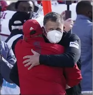  ?? CARLOS OSORIO — THE ASSOCIATED PRESS ?? Rutgers head coach Greg Schiano, with a mask, is hugged by an assistant after his team defeated Michigan State on Oct. 24 in East Lansing.