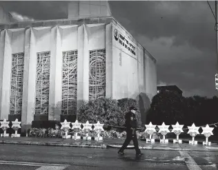  ?? Gene J. Puskar / Associated Press ?? A memorial of flowers and stars outside the Tree of Life Synagogue serves as a remembranc­e to those killed and injured when a shooter opened fire at the synagogue in Pittsburgh.