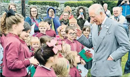  ?? ANTHONY DEVLIN / GTRES ?? Carlos charla con unos niños, durante su visita a Aberystwyt­h, en Gales, la semana pasada