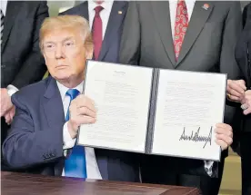  ?? AFP ?? Donald Trump muestra la resolución tras su firma, ayer en la Casa Blanca.