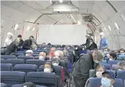  ?? REUTERS ?? US passengers are seen on board a chartered evacuation aircraft as they prepare to fly home yesterday.