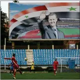  ??  ?? CASTING A SHADOW: Syria’s national team train below the image of Bashar al-Assad