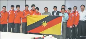  ??  ?? Soh (fourth right) receives Sarawak colours as team manager from Aziz, while SBA secretary Abdul Hadi Abdul Kadir (fifth right), and Sukma Melaka 2010 players and officials look on.