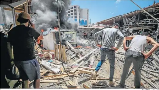  ?? MOHAMMED SABER / EFE ?? Varias personas inspeccion­an los daños causados tras el ataque aéreo israelí a un coche, ayer en Gaza.