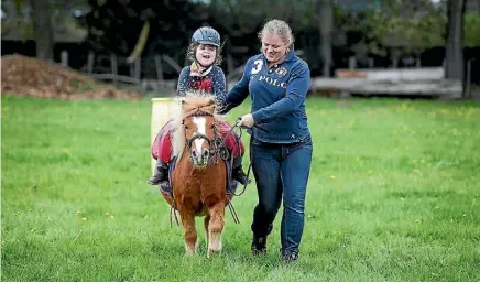  ??  ?? Suzy McMenamin helps her daughter Charlotte ride her pony Merlin.