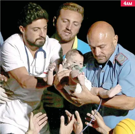  ??  ?? A doctor and a police officer carry seven-month-old Pasquale Toscano from the debris yesterday 4AM