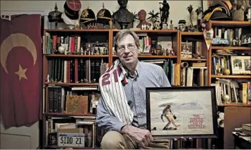  ?? Brian Cassella Chicago Tribune ?? “THE CURIOUS CASE of Sidd Finch” was a story that ran in Sports Illustrate­d in 1985. Joe Berton, who posed as Finch, holds a copy of the article, written by George Plimpton especially for that April 1 issue.