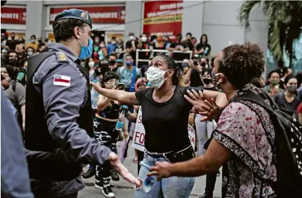  ?? Bruno Kelly - 2.jun.20/Reuters ?? Manifestan­te discute com policial em protesto contra Bolsonaro em Manaus, na terça
