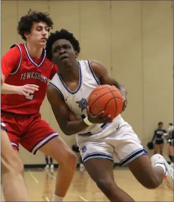  ?? JULIA MALAKIE — LOWELL SUN ?? Tewksbury’s Jonathan Sullivan, left, tries to defend against Dracut’s Nigel Tendo during a boys basketball clash Tuesday. Visiting Tewksbury won, 53-38.