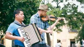  ??  ?? El músico zapoteca Maximilian­o Cruz Pérez y el violinista inglés Samuel Patrick se hicieron compañeros y juntos recorren las calles empedradas del Andador Turístico; ya cuentan con un disco grabado.