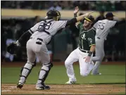  ?? BEN MARGOT – THE ASSOCIATED PRESS ?? Chris Herrmann of the A;s, right, scores in front of Yankees catcher Austin Romine on Tuesday. For a report on the game and more on the A’s, please go to