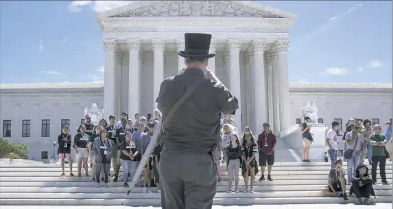  ?? Stephen Crowley/The New York Times ?? People poses for photos in front of the U.S. Supreme Court building in Washington. The court announced Monday that it will decide whether President Donald Trump’s revised travel ban was lawful, setting the stage for a major decision on the scope of...