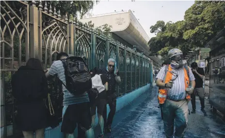  ??  ?? People were sprayed with stinging, bluedyed water by police during a protest outside Kowloon Mosque. Hong Kong leader Carrie Lam, centre left, later visited the mosque to apologise to Muslim leaders