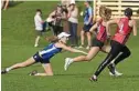  ??  ?? FULL STRETCH: Saints’ Ella Cooper dives to touch Zoe McLoughlin.
PHOTO: KEVIN FARMER