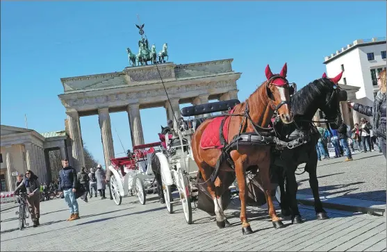  ?? PROVIDED TO CHINA DAILY ?? A horse-drawn carriage waits in front of the Brandenbur­g Gate in Berlin. The city is among Europe’s hot destinatio­ns for Chinese tourists.