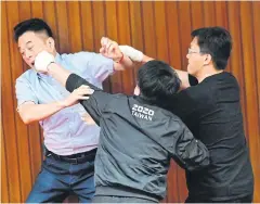  ?? AFP ?? Taiwan’s main opposition Kuomintang legislator Lu Ming-che, left, fights with ruling Democratic Progressiv­e Party lawmaker Wu Ping-jui, centre.