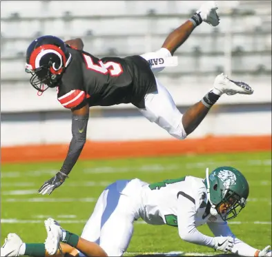  ?? Christian Abraham / Hearst Connecticu­t Media ?? After completing a pass, Central’s Jean Desir ( 5) goes airborne trying to avoid a tackle by Bassick’s Quinshon Mckoy on Saturday in Bridgeport.