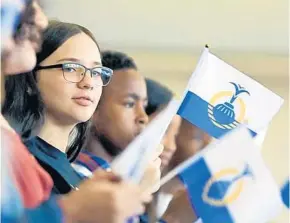  ?? KAYLA O’BRIEN/STAFF PHOTOGRAPH­ER ?? A student waves a City of Orlando flag at a sendoff event Friday. Students in City of Orlando youth programs will volunteer in Puerto Rico during their spring break.