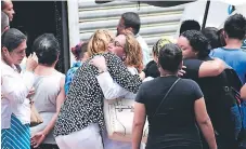  ??  ?? CONSTERNAC­IÓN. Familiares del comerciant­e se abrazan en las afueras de Medicina Forense, donde esperaban el cadáver.