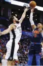  ?? [PHOTO BY NATE BILLINGS, THE OKLAHOMAN] ?? Oklahoma City’s Russell Westbrook, right, puts a shot over San Antonio’s Joffrey Lauvergne during Sunday night’s game at Chesapeake Energy Arena. Oklahoma City won the game, 90-87.