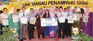  ??  ?? YAHYA (lima kiri) bersama Siti Salmiah (tujuh kiri) semasa penyerahan Akhbar Tutor Utusan Malaysia kepada sekolah-sekolah kawasan DUN Petagas.