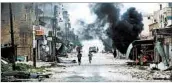  ?? OMAR HAJ KADOUR/GETTY-AFP ?? Fighters make their way through a street in Tayyibat alImam, a town Aleppo province.