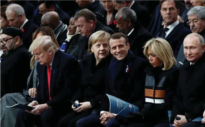  ?? BENOIT TESSIER, REUTERS/NTB SCANPIX ?? President Donald Trump, til venstre, bivånet fredsmarke­ringen sammen med Tysklands Angela Merkel, Frankrikes Emmanuel Macron og Russlands president Vladimir Putin ved Triumfbuen i Paris i går.