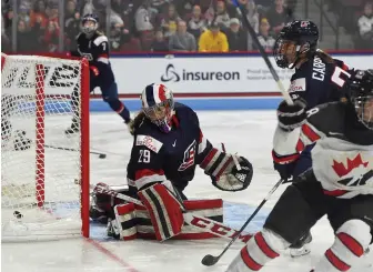  ?? STAFF PHOTOS BY CHRISTOPHE­R EVANS ?? NET LOSS: Team USA goalie Nicole Hensley (above) can only watch as the puck gets past her for a goal during the second period of last night’s 5-1 exhibition loss to Canada at Agganis Arena; (below) Brianna Decker skates the puck up ice while being...