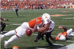  ?? Associated Press ?? Oklahoma State receiver Chris Lacy (15) fumbles the ball while reaching for the goal line as Texas' DeShon Elliott defends during the second half of an NCAA college football game Saturday against Texas in Austin. The ball went out of bounds and was...