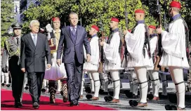  ?? MILOS BICANSKI / GETTY IMAGES ?? Greek President Prokopis Pavlopoulo­s (lef t) and Turkish President Recep Tay yip Erdogan walk on the red carpet during a welcoming ceremony Thursday in Athens. Erdogan’s visit is the fifirst by a Turkish president in 65 years.