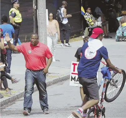  ?? STAFF FILE PHOTO BY NICOLAUS CZARNECKI ?? ROLL WITH IT: Mayoral candidate City Councilor Tito Jackson waves to the crowd as a member of the New England Bike Life group performs a stunt during Saturday’s Caribbean Carnival Parade.