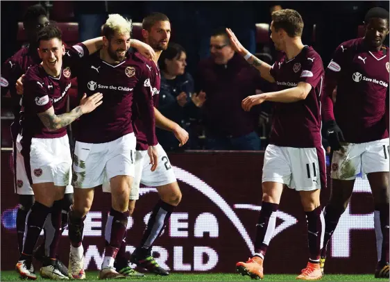 ??  ?? MAIN MAN: Gorgie hero Juanma (centre) is hailed by team-mates after his winner for Hearts and was later praised by skipper Ozturk for his all-action performanc­e