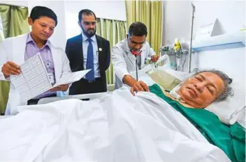  ?? Ahmed Ramzan/ Gulf News ?? Dr Alai Taggu, Dr Sherbaz Bichu and Dr Chaitanya Prabhu attending to Alicia De Los R at Aster Hospital Mankhool, Dubai. She has been lying in a vegetative state at the hospital since June 7 when she suffered a massive cardiac arrest.
