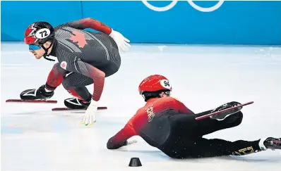  ?? ANNE-CHRISTINE P O U J O U L AT GETTY IMAGES ?? Canada’s Pascal Dion skates past fallen Chinese skater Li Wenlong in the short-track relay semifinals. Later, a review determined there was no illegal contact in the race, and both teams advanced to the final.