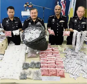  ??  ?? Evidence in hand: DCP Roslee (second left) and his officers showing the drugs and fake pills seized.
