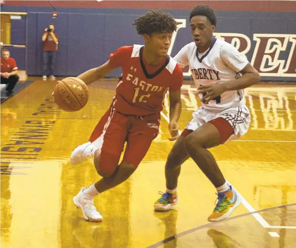  ?? PHOTOS BY JANE THERESE/SPECIAL TO THE MORNING CALL ?? Easton’s Aaron Clark drives around Liberty’s Rahmad Ali on Saturday night during the teams’ game in Bethlehem. Clark scored 25 points to help the Red Rovers earn a victory.