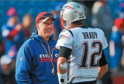  ?? PHOTO BY TOM SZCZERBOWS­KI/GETTY IMAGES ?? Jim Kelly talks with Tom Brady #12of the New England Patriots before a game against the Buffalo Bills December 3, 2017at New Era Field in Orchard Park, New York.