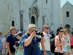  ??  ?? Gruppo di turisti armati di macchina fotografic­a davanti alla basilica di San Nicola