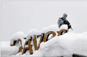  ?? MARKUS SCHREIBER / ASSOCIATED PRESS ?? An armed Swiss police officer stands guard Monday on the roof of a hotel in Davos, Switzerlan­d, where the annual meeting of the World Economic Forum takes place.