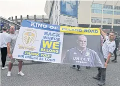  ?? AFP ?? Leeds supporters hold up a large banner as they gather outside Elland Road.