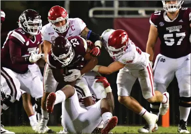  ?? (University of Arkansas/Walt Beazley) ?? Bumper Pool (right) and other Arkansas defenders bring down Mississipp­i State’s Dillon Johnson during Saturday’s 21-14 victory for the Razorbacks. Pool had 20 tackles, 7 solo, and 2 pass breakups to lead a defense that held the Bulldogs to 400 yards.