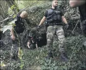  ?? (Photo AFP) ?? Les gendarmes fouillent les moindres recoins de la zone boisée jouxtant la salle des fêtes.