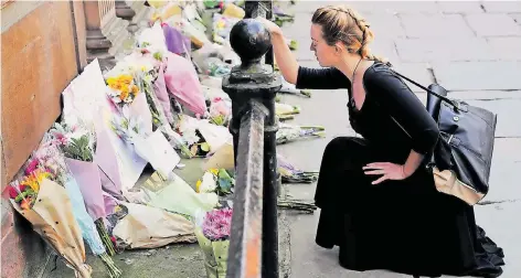  ?? FOTO: REUTERS ?? Eine junge Frau gedenkt im Zentrum von Manchester der Opfer des Terroransc­hlags von Montagaben­d.